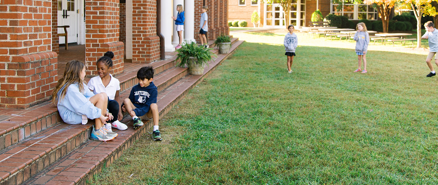 Students sitting on steps of Canterbury campus